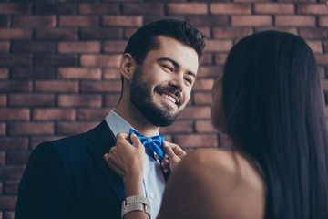 Closeup photo of two affectionate people couple guy looking eyes lady who fixing blue stylish bow...