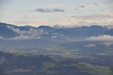 a zeppelin airship flying over the Alps seen from the Pfänder, Voralberg, Austria © Simo
