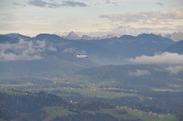 a zeppelin airship flying over the Alps seen from the Pfänder, Voralberg, Austria