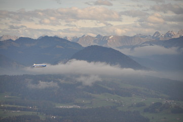 a zeppelin airship flying over the Alps seen from the Pfänder, Voralberg, Austria © Simo