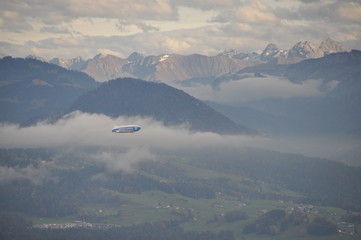 a zeppelin airship flying over the Alps seen from the Pfänder, Voralberg, Austria © Simo