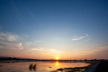 Obraz premium Beautiful sunset reflected in the lake.Fiery orange sunset sky. Beautiful sky
