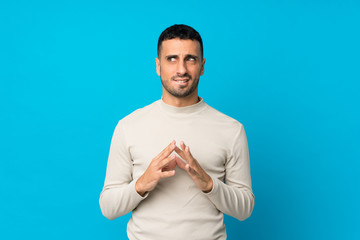 Young man over isolated blue background scheming something