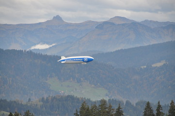 a zeppelin airship flying over the Alps seen from the Pfänder, Voralberg, Austria © Simo