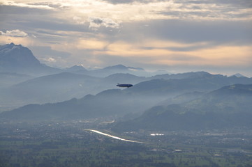 a zeppelin airship flying over the Alps and the Rhine valley seen from the Pfänder, Voralberg, Austria © Simo