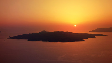 Beautiful sunset in picturesque village of Fira with golden colours, Santorini island, Cyclades, Greece