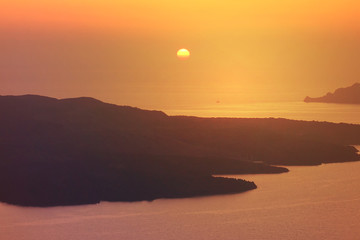 Beautiful sunset in picturesque village of Fira with golden colours, Santorini island, Cyclades, Greece