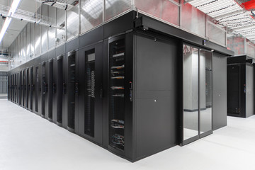 Shot of a long hallway full server racks in a modern data center. Server room.
