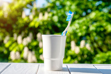 Toothbrush stands in a glass on a natural background 