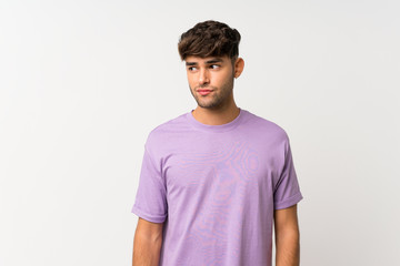 Obraz premium Young handsome man over isolated white background making doubts gesture looking side