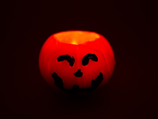 Halloween Pumpkin Shaped Candle and Flame on black background