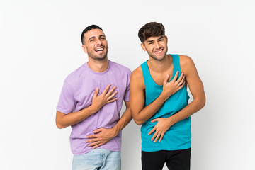 Fototapeta premium Two men over isolated background smiling a lot while putting hands on chest