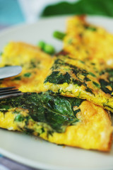 healthy breakfast, egg frittata with spinach, dill, green peas on a light background