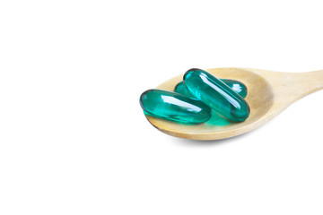 Aqua blue soft capsules on wooden spoon isolated on white background.File contains a clipping path.