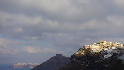 Fototapeta na wymiar Picturesque and beautiful village of Fira overlooking the caldera with beautiful clouds and blue sky, Santorini island, Cyclades, Greece