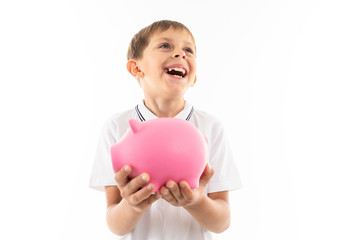 happy schoolboy with a piggy bank in his hands laughs on a white isolated background