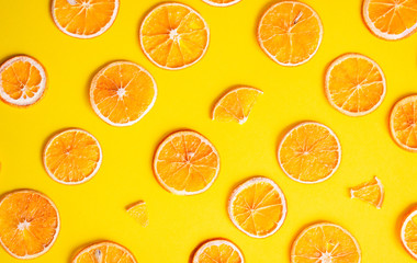 Creative pattern made of dried orange fruit slices on pastel orange paper background. Fruit minimal concept. Geometric pattern of orange slices on color background. 