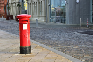 Angielska czerwona  skrzynka pocztowa na ulicy - obrazy, fototapety, plakaty