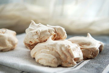 Obraz na płótnie Canvas Homemade white meringue cookies on linen textile. Selective focus. Morning light. Beautiful dessert or breakfast.