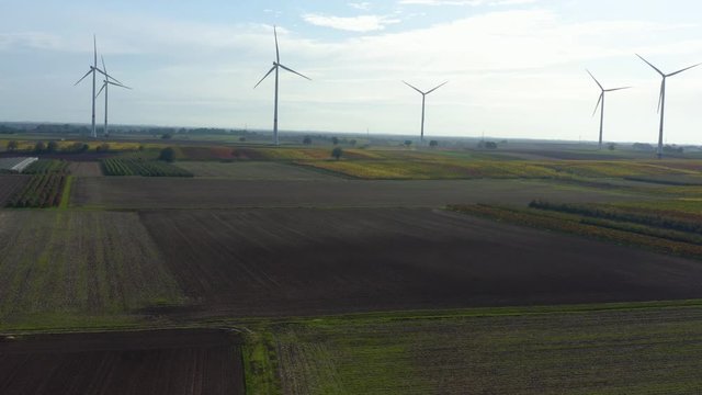Aerial view of wind turbines beside vineyards in Germany. On a sunny day in Autumn, fall. Zoom in on the turbines.