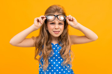 schoolgirl with glasses raises glasses over her eyes, poorly seeing child