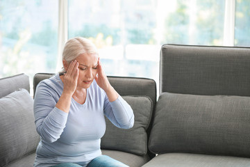 Mature woman suffering from headache at home