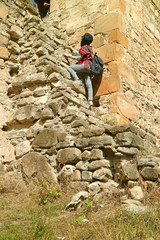 Obraz na płótnie Canvas Visitor climbing up to the Sheupovari tower inside the Ananuri medieval castle complex, Georgia