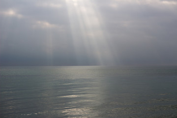  the rays of the sun break through the clouds at sea