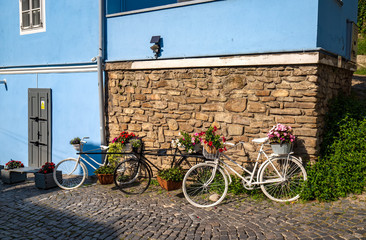 Three bicycles as flowerbed on empty olg street in Sighisoara, Romania
