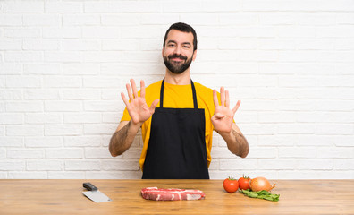 Chef holding in a cuisine counting nine with fingers