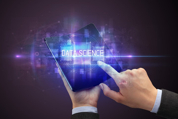 Businessman holding a foldable smartphone with DATA SCIENCE inscription, new technology concept