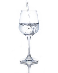 A glass of wine pouring water on a white background