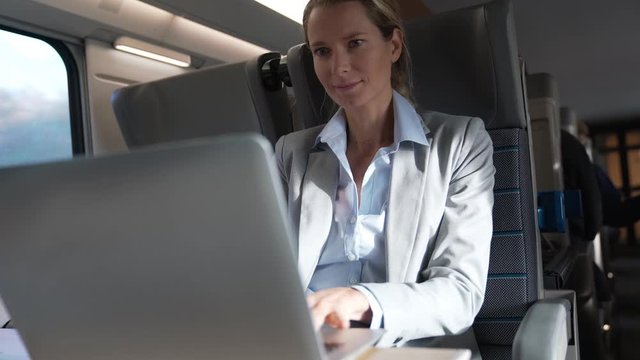 businesswoman working on a train in business class