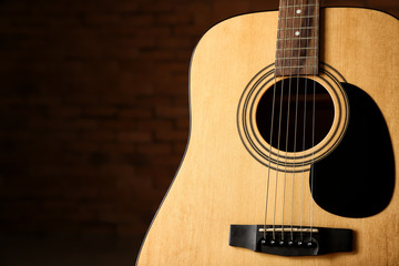 Modern acoustic guitar against dark background, closeup