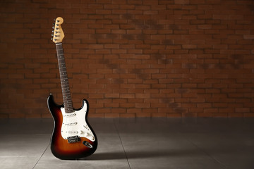 Modern bass guitar against dark brick wall