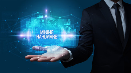 Man hand holding MINING HARDWARE inscription, technology concept