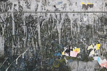 dirty texture of a metallic wall with paint stains and peeled paper fragments