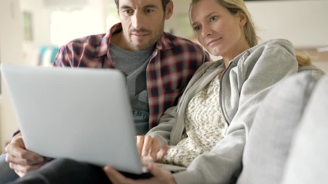young couple watching a movie on a computer