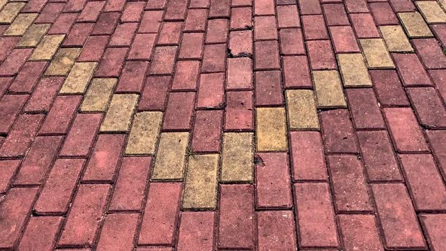 4K - Slow motion on the pavement of red bricks with yellow lozenge motifs in a Chinese public park.