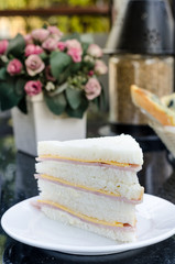 The toast sandwiches served with ham and cheese on a white dish.