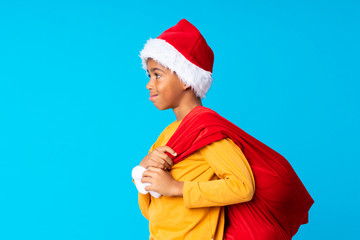 African American boy with christmas hat and taking a bag with gifts