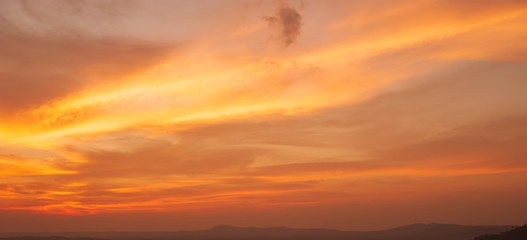 Dramatic sunrise sky over a mountain range.