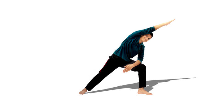 Full-length shot of male energetic young teenager isolated on white background doing waist twisting exercise by bending on one side with one hand stretched out in air. Male active pose. Active pose.