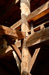 large wooden beams in an old building with sunlight rays