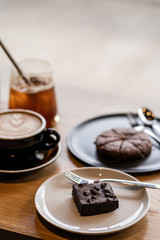 Set of Dessert food and drink Latte coffee, Iced coffee, chocolate brownie cookies and cake on the wooden cafe table.