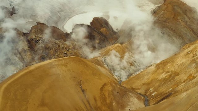 Aerial: Epic Yellow sand Steamy mountain Kerlingarfjoll Geothermal area in Highlands of Iceland Cloudy gloomy day
