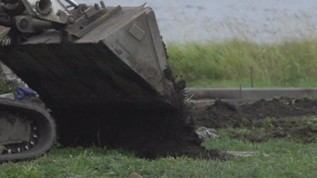 road construction: scraper-bulldozer (earth-mover) pours soil for highway building