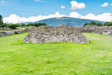 Ruins of the architecturally significant Mesoamerican pyramids and green grassland located at at Teotihuacan, an ancient Mesoamerican city located in a sub-valley of the Valley of Mexico