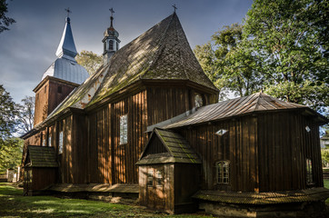 Fototapeta na wymiar Wooden Roman Catholic church dedicated to Saint. Nicholas in Polanka Wielka village, Poland. Built in the first half of the sixteenth century, in 1658 rebuilt in the Baroque style.