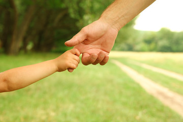  parent holds the hand of a small child